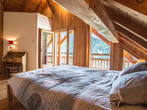 ヴォジャニーにあるLuxurious Chalet in Vaujany French Alps with Balconyのベッドルーム1室(ベッド1台、デスク、窓付)
