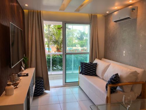 salon z białą kanapą i dużym oknem w obiekcie Palm Acqua Resort w mieście Porto de Galinhas