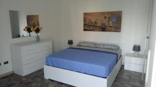a white bedroom with a bed and two dressers at Casa Vacanze Leo 2 in Acquarica del Capo