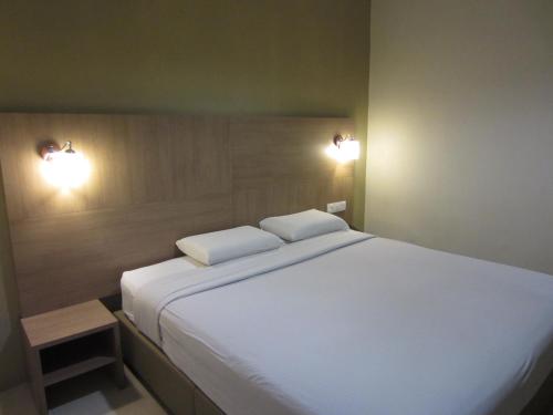 een slaapkamer met een groot wit bed met 2 kussens bij Radiant Hotel in Sitiawan