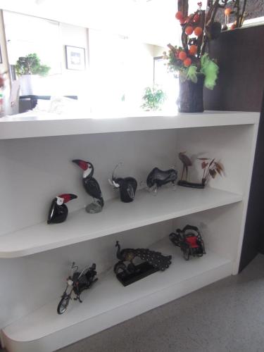 a white shelf with a bunch of shoes on it at Radiant Hotel in Sitiawan
