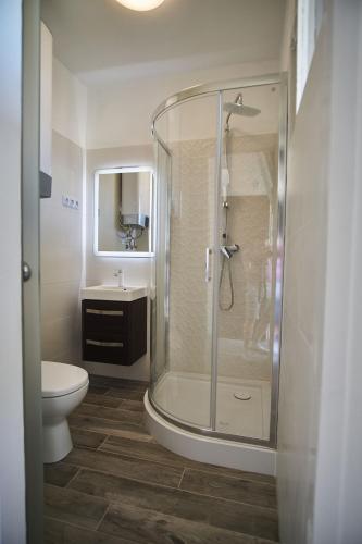 Füredem Apartman في بالاتونفوريد: حمام مع دش ومرحاض ومغسلة