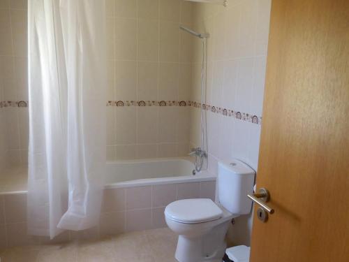 a bathroom with a toilet and a shower and a tub at Casa Amarela by Umbral in Pêra