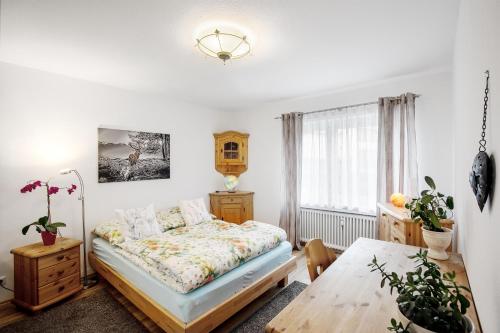 ein kleines Schlafzimmer mit einem Bett und einem Tisch in der Unterkunft Sweet Home & Flower Garden in Garmisch-Partenkirchen