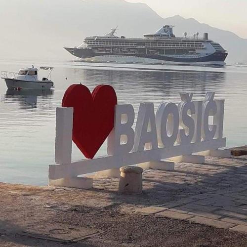 a heart on a bench with a cruise ship in the water at Apartman Gušt in Herceg-Novi