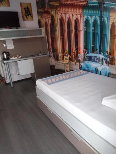 ein Bett in einem Zimmer mit einem Auto auf dem Boden in der Unterkunft Самостоятелни студия in Kardschali