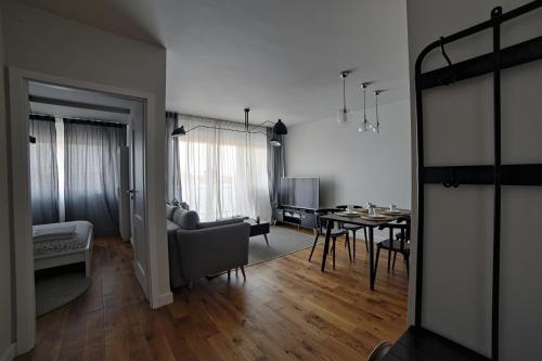 salon z kanapą i stołem w obiekcie One Apartment w mieście Śrem