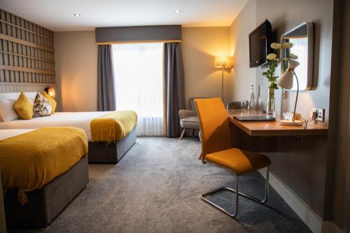 ein Hotelzimmer mit einem Bett und einem Schreibtisch in der Unterkunft Hotel Doolin in Doolin