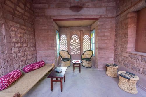 a room with chairs and a couch in a brick wall at Baijoo Niwas in Jodhpur