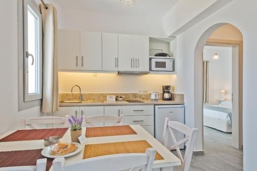 a kitchen and dining room with a table and chairs at Alsalos villas in Amoopi