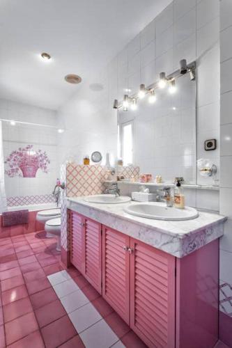 a bathroom with two sinks and a mirror and two toilets at Villa Paquita in Calella