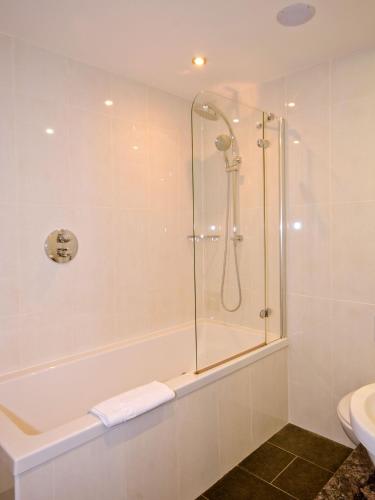 a bathroom with a shower and a toilet and a sink at The Kinmel & Kinspa in Abergele