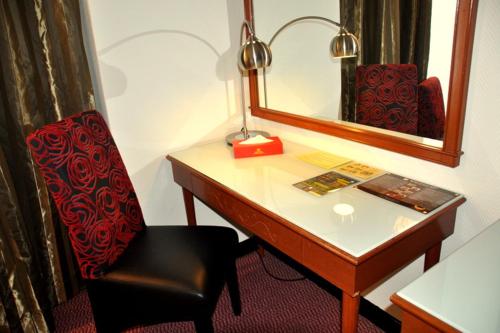a desk with a chair and a mirror at Hotel Grand Continental Kuantan in Kuantan
