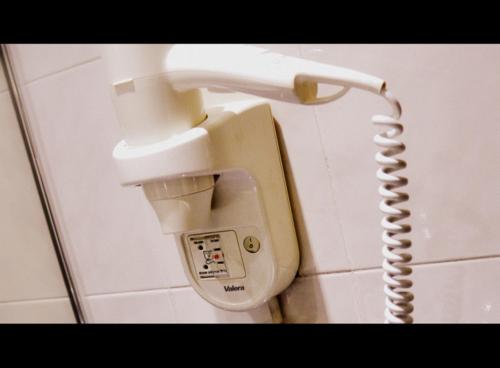 a telephone hanging on a wall in a bathroom at Hotel Grand Continental Kuantan in Kuantan