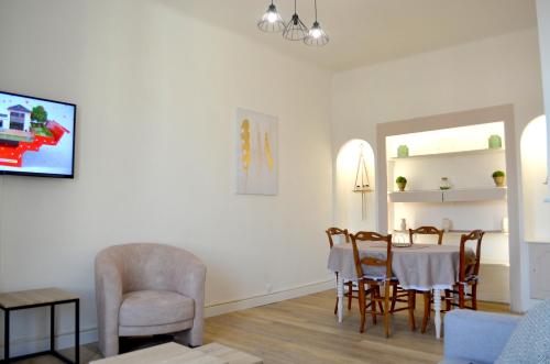 a living room with a dining room table and chairs at 2 Pièces Liberté Plein Centre in Saint-Raphaël