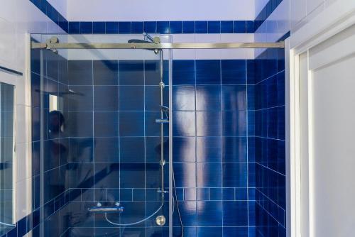 una doccia piastrellata blu con una persona di LUXURY NAPOLITANO a Sorrento