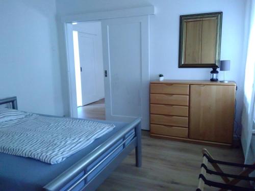 um quarto com uma cama, uma cómoda e um espelho em Ruhige Wohnung zentrumsnah em Pirmasens