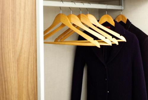 a closet with a black shirt and wooden hangers at Residence Alleterme in Rivanazzano