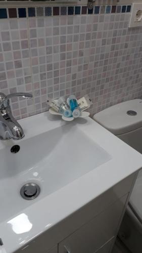 a bathroom sink with a toothbrush and toothpaste at Apartamento La Campanina in La Alberca