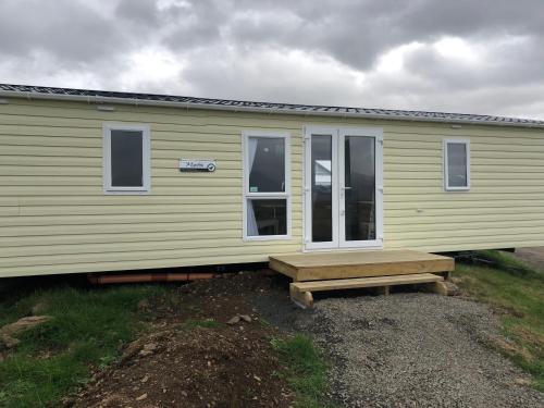 a small yellow house with a bench in front of it at Lækjarkot Rooms and Cottages with Kitchen in Borgarnes