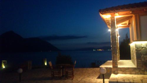 a gazebo with a table and chairs at night at Thesmos Village in Mýtikas