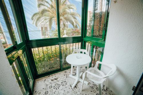 a table and two chairs in a room with a window at Apartamentos Palm Court in Benidorm