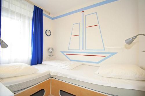 a bedroom with two beds with a sail on the wall at Vier Jahreszeiten 6-4 in Großenbrode