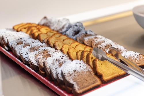 a plate of food with bread and powdered sugar at Palm Beach Hotel - Adults only in Kos Town