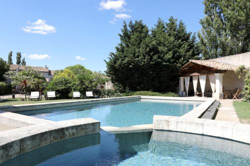una piscina en un patio con sillas y árboles en Chambres d'Hôtes Justin de Provence en Orange