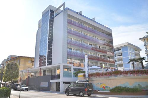 a tall building with cars parked in front of it at Hotel Amburgo in Bibione