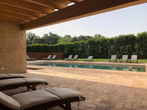 eine Terrasse mit Stühlen und einem Pool in der Unterkunft El Moli de Siurana in Siurana