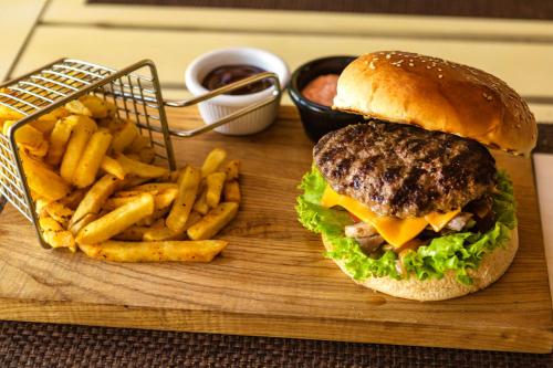 a hamburger and french fries on a cutting board at Faros Bodrum Hotel - Special Category in Golturkbuku