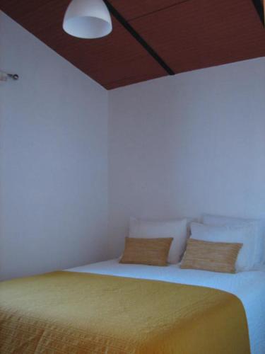 メルトラにあるCasa da Avó Minaの白いベッドルーム(黄色い毛布付きのベッド付)