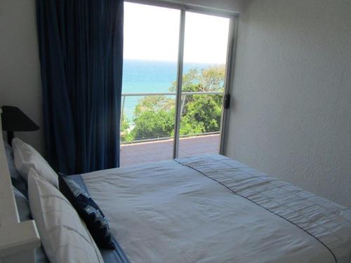 a bedroom with a bed with a view of the ocean at 74 Cascades in Durban