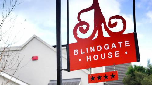 un cartello rosso cieco della casa dei cavoli appeso a un palo di Blind Gate House a Kinsale