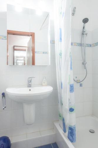 a white bathroom with a sink and a shower at Vier Jahreszeiten 2-86 in Großenbrode