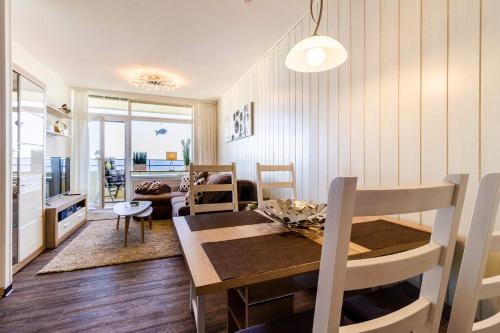 uma sala de jantar e sala de estar com mesa e cadeiras em Vier Jahreszeiten 2-87 em Grossenbrode