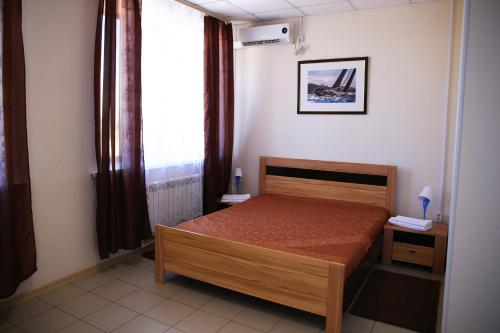 アフトゥビンスクにあるKoleso Mini-Hotelの小さなベッドルーム(ベッド1台、窓付)