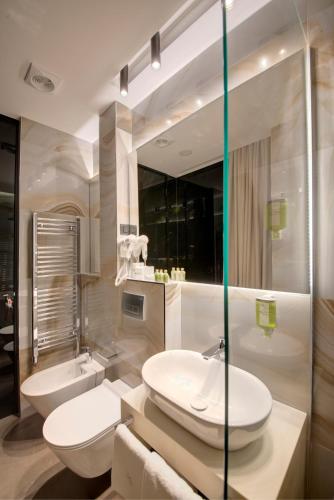 a bathroom with a sink and a toilet and a tub at Heritage Hotel Leon Coronato in Perast