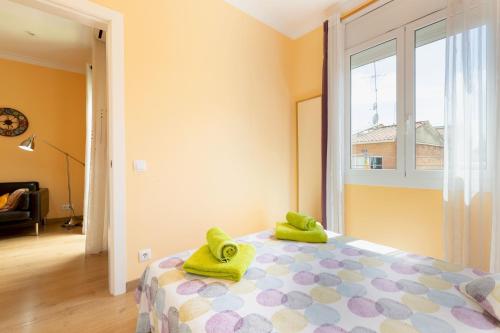 a bedroom with a bed with green towels on it at Lodging Apartments Guell & Gracia in Barcelona
