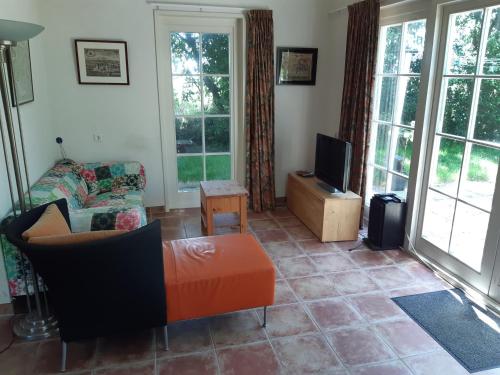 a living room with a couch and a tv at Zeeuws Huisje Colijnsplaat in Colijnsplaat