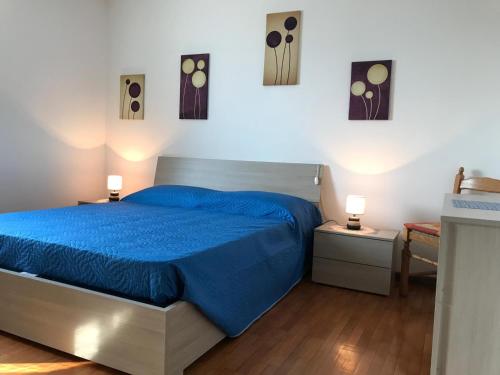 ein Schlafzimmer mit einem blauen Bett und zwei Nachttischen in der Unterkunft Appartamento Pezzol in Daiano