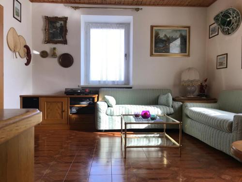 ein Wohnzimmer mit einem Sofa und einem Tisch in der Unterkunft Appartamento Pezzol in Daiano