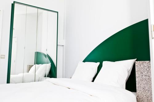 a bedroom with a white bed and a mirror at Hotel Siru Brussels in Brussels