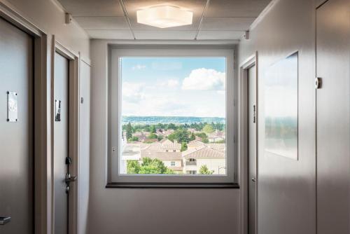 a window in a hallway with a view at Kyriad Lyon Est Stadium Eurexpo Meyzieu in Meyzieu