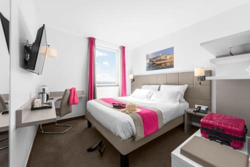 a hotel room with a bed and a window at Kyriad Lyon Est Stadium Eurexpo Meyzieu in Meyzieu