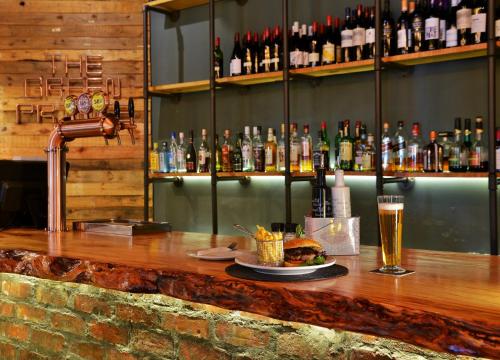 a bar with a plate of food and a glass of beer at Mont d'Or Swartberg Hotel in Prince Albert
