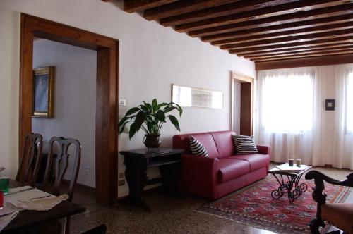 a living room with a red couch and a table at Appartamenti San Luca in Venice