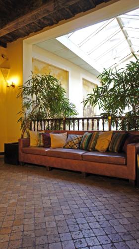 a large couch sitting in a room with plants at Grand Hotel Praha in Prague