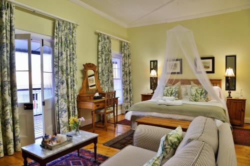 a bedroom with a bed with a canopy at Swartberg Hotel, Cork Tree Collection in Prince Albert
